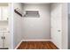 Convenient mudroom area with hooks, coat rack, white cabinetry, and wood-look flooring at 11375 Ogden Mills Dr # 103, Las Vegas, NV 89135