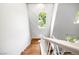 Staircase features wood-look flooring, white railings, and a view out the window at 11375 Ogden Mills Dr # 103, Las Vegas, NV 89135