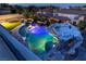 Night aerial of a custom pool with water slide, spa and color lighting at 1204 Moselle Ct, Las Vegas, NV 89144