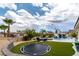 Sprawling backyard with lush landscaping, pool with slide, spa, and trampoline at 1204 Moselle Ct, Las Vegas, NV 89144