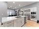 Bright kitchen features white cabinets, stainless steel appliances, and a center island with quartz countertop at 1204 Moselle Ct, Las Vegas, NV 89144