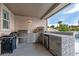 Outdoor kitchen complete with a built-in grill, pizza oven, bar and refrigerator for outdoor enjoyment at 1204 Moselle Ct, Las Vegas, NV 89144