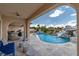 Lush backyard featuring a swimming pool with slide, outdoor kitchen, and covered patio at 1204 Moselle Ct, Las Vegas, NV 89144