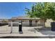 This single-story home with gray exterior features a secure white fence and drought-resistant landscaping in front yard at 125 S 15Th St, Las Vegas, NV 89101