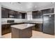 Beautiful kitchen featuring dark cabinets, stainless steel appliances, granite countertops, and an island, enhancing functionality at 125 S 15Th St, Las Vegas, NV 89101
