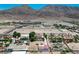 Property aerial highlighting desert landscaping, mature trees and mountain views in the distance at 1345 Morning Sun Way, Las Vegas, NV 89110