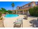 The beautiful backyard features a pool with a rock waterfall, lush landscaping, and mature trees at 1345 Morning Sun Way, Las Vegas, NV 89110