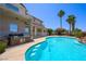 Backyard features a pool, a built-in BBQ, manicured landscaping, mature palm trees, and patio seating at 1345 Morning Sun Way, Las Vegas, NV 89110