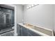 Bathroom features a modern vanity with open storage and a glass-enclosed shower with marble tiling at 1345 Morning Sun Way, Las Vegas, NV 89110