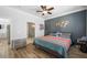 Cozy bedroom with ceiling fan, dark accent wall, and hardwood style floors, near bathroom at 1345 Morning Sun Way, Las Vegas, NV 89110