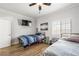 Clean bedroom featuring two beds, hardwood floors, and a ceiling fan and mounted TV at 1345 Morning Sun Way, Las Vegas, NV 89110