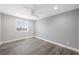 Bright bedroom with gray walls, wood-look floors, white trim, a window, and a ceiling fan at 1345 Morning Sun Way, Las Vegas, NV 89110