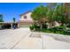 Attractive two-story stucco home with a two-car garage, carport, mature trees, and grass at 1345 Morning Sun Way, Las Vegas, NV 89110