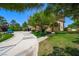View of lush green lawn and landscaping leading to the front of this spacious home with a circular driveway at 1345 Morning Sun Way, Las Vegas, NV 89110