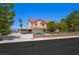 Charming two-story home with mature trees and an iron fence and gate in front at 1345 Morning Sun Way, Las Vegas, NV 89110
