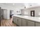 Open kitchen featuring a large island, modern countertops and wood floors with open access to living room at 1345 Morning Sun Way, Las Vegas, NV 89110