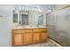 Bright bathroom featuring double sinks, oak cabinets, and a glass-enclosed shower at 1620 Fieldbrook St, Henderson, NV 89052