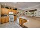 Functional kitchen features countertops, wooden cabinets, modern appliances, and a breakfast bar overlooking backyard at 1620 Fieldbrook St, Henderson, NV 89052