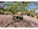 Relaxing backyard featuring a covered patio, spa, desert landscaping, and mature trees at 1620 Fieldbrook St, Henderson, NV 89052