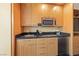 Kitchenette featuring light wood cabinets, a microwave, black countertop, and stainless-steel appliances at 2000 N Fashion Show Dr # 2704, Las Vegas, NV 89109