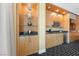 Kitchenette with light wood cabinets, a black countertop, shelving, and decorative items set on patterned black and white carpeting at 2000 N Fashion Show Dr # 2704, Las Vegas, NV 89109