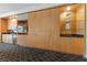 Condo kitchenette with wood cabinets, countertop, microwave, TV, and decorative shelving against patterned black and white carpeting at 2000 N Fashion Show Dr # 2704, Las Vegas, NV 89109
