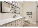 Bright bathroom with a white vanity, quartz countertop, and a large framed mirror reflecting a shower at 2108 Calville St # 104, Las Vegas, NV 89128
