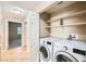 Laundry area with a washer, dryer, and shelving for storage, conveniently located inside the home at 2108 Calville St # 104, Las Vegas, NV 89128