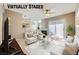 Staged living room with neutral colors, a white sofa, a fireplace, and a sliding glass door for outdoor access at 2108 Calville St # 104, Las Vegas, NV 89128