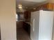 Kitchenette with wood cabinets, tile floors and white refrigerator at 228 Caracas Dr, Las Vegas, NV 89145