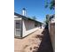Sideyard with fresh exterior paint, rock ground cover, and mature trees in a well-maintained landscape at 2318 El Molino Cir, Las Vegas, NV 89108