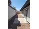 Sideyard with fresh exterior paint, rock ground cover, concrete patio, and privacy fence at 2318 El Molino Cir, Las Vegas, NV 89108
