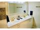 Modern bathroom with dual sinks, brass fixtures, and decorative cabinetry with crystal knobs at 2659 Vegas Valley Dr, Las Vegas, NV 89121