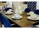 Elegant dining table beautifully set with white china, blue velvet chairs, and floral centerpiece at 2659 Vegas Valley Dr, Las Vegas, NV 89121