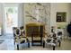 Cozy sitting area with floral chairs, stylish marble fireplace, and natural light streaming through the doors at 2659 Vegas Valley Dr, Las Vegas, NV 89121