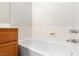 Clean bathroom view featuring a white bathtub, tiled walls, and wooden vanity at 3161 Quail Song Dr # 3161, Laughlin, NV 89029