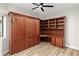 Bedroom featuring a murphy bed, custom cabinetry, and wood-look floors at 3161 Quail Song Dr # 3161, Laughlin, NV 89029