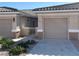 Inviting home exterior with a neutral color palette, landscaped yard, and charming gated courtyard entrance at 3161 Quail Song Dr # 3161, Laughlin, NV 89029