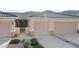 Exterior home view with a two-car garage, desert landscaping, and clear mountain views at 3161 Quail Song Dr # 3161, Laughlin, NV 89029