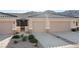 Exterior shot featuring a two-car garage, desert landscaping, and clear mountain views at 3161 Quail Song Dr # 3161, Laughlin, NV 89029