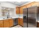 Kitchen featuring wood cabinets, stainless steel appliances, and a passthrough to the living room at 3161 Quail Song Dr # 3161, Laughlin, NV 89029
