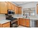 Bright kitchen featuring stainless steel appliances, wood cabinets and quartz countertops at 3161 Quail Song Dr # 3161, Laughlin, NV 89029