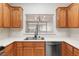 Kitchen with wood cabinets and a passthrough to the living room with modern lighting at 3161 Quail Song Dr # 3161, Laughlin, NV 89029