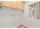 Functional laundry room featuring wood-style flooring, window for natural light, and overhead cabinetry at 3161 Quail Song Dr # 3161, Laughlin, NV 89029