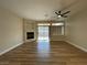 Spacious living room with wood floors, fireplace, a ceiling fan and access to the patio at 3161 Quail Song Dr # 3161, Laughlin, NV 89029
