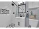 Modern bathroom with a white vanity, black fixtures, and a beautifully tiled shower and floor with geometric patterns at 3509 Navajo Way, Las Vegas, NV 89108