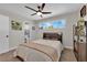 A comfortable bedroom with a ceiling fan, large window with a view, and a doorway leading to the ensuite bathroom at 3509 Navajo Way, Las Vegas, NV 89108