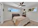A cozy bedroom featuring neutral walls, carpet, a ceiling fan, and a large window allowing natural light to fill the space at 3509 Navajo Way, Las Vegas, NV 89108