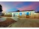 Inviting single-story house with cozy front yard seating and exterior lighting at twilight at 3509 Navajo Way, Las Vegas, NV 89108