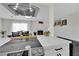 Modern kitchen with stainless steel appliances, white cabinets, and view of the dining area with a fireplace at 3509 Navajo Way, Las Vegas, NV 89108